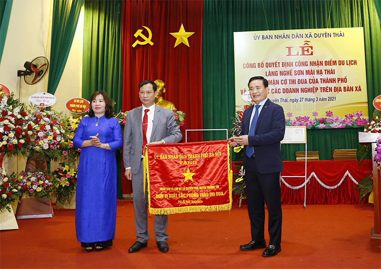 Ông Vũ Mạnh Hải, Đại biểu HĐND thành phố, Chủ tịch hội nghệ nhân giỏi thành phố trao cơ thi đua cho lãnh đạo xã.