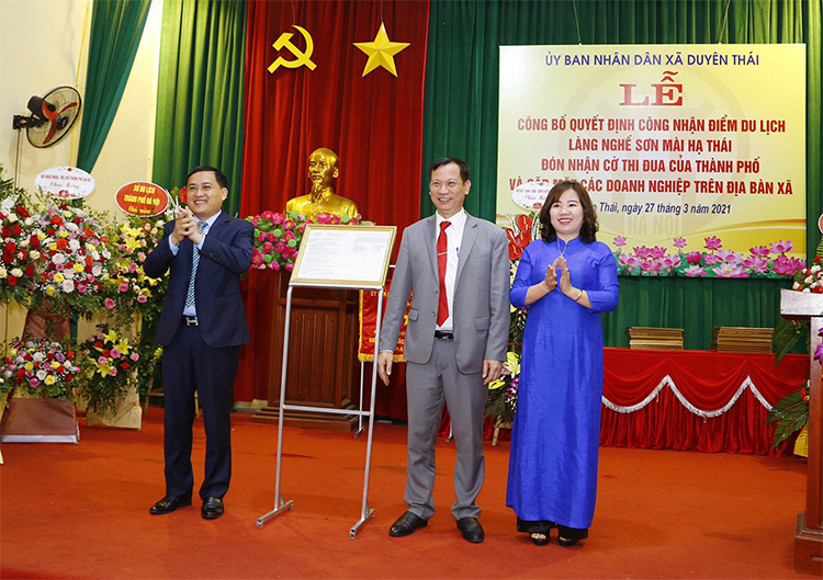 Ông Bùi Công Thản, Phó Chủ tịch UBND huyện Thường Tín trao quyết định công nhận điểm du lịch làng nghề sơn mài Hạ Thái cho lãnh đạo xã Duyên Thái.