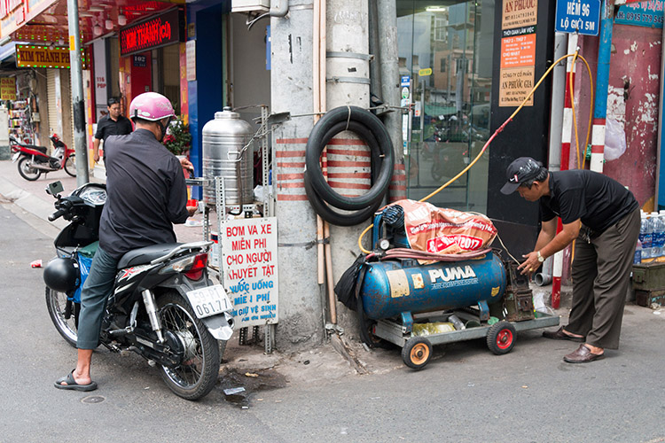 Việc bơm, vá xe miễn phí cho người khuyết tật do một mình anh Đỗ Văn Út (Việt) phụ trách