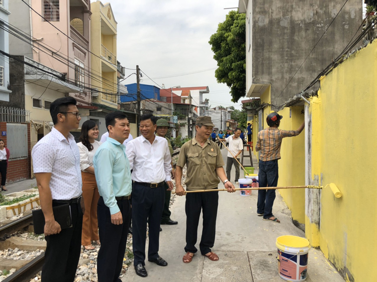 Lãnh đạo quận Lê Chân giám sát việc sơn tường cho nhà dân bên đường tàu.