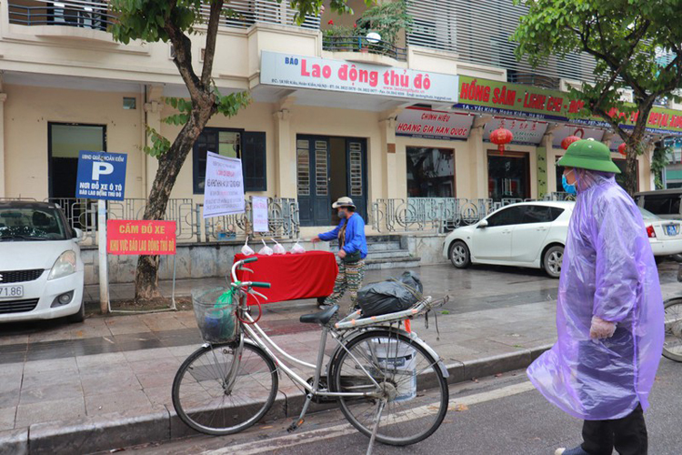 Mặc dù trời mưa, người dân vẫn đến địa điểm phát thực phẩm miễn phí tại Trụ sở Báo Lao động Thủ đô, số 1A Yết Kiêu. (Ảnh: Minh Phương)