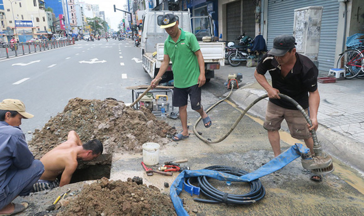 Công nhân Công ty cổ phần Cấp thoát nước Gia Định sửa chữa ống nước trên đường Hoàng Văn Thụ, P.9, Q.Phú Nhuận - Ảnh: Tuổi trẻ
