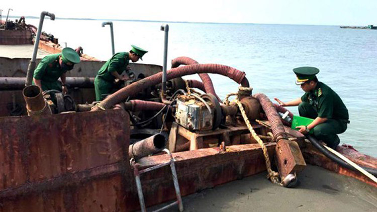 Bộ đội Biên phòng TPHCM xử lý một sà lan bơm hút cát trái phép trên biển Cần Giờ. Ảnh: SGGP.