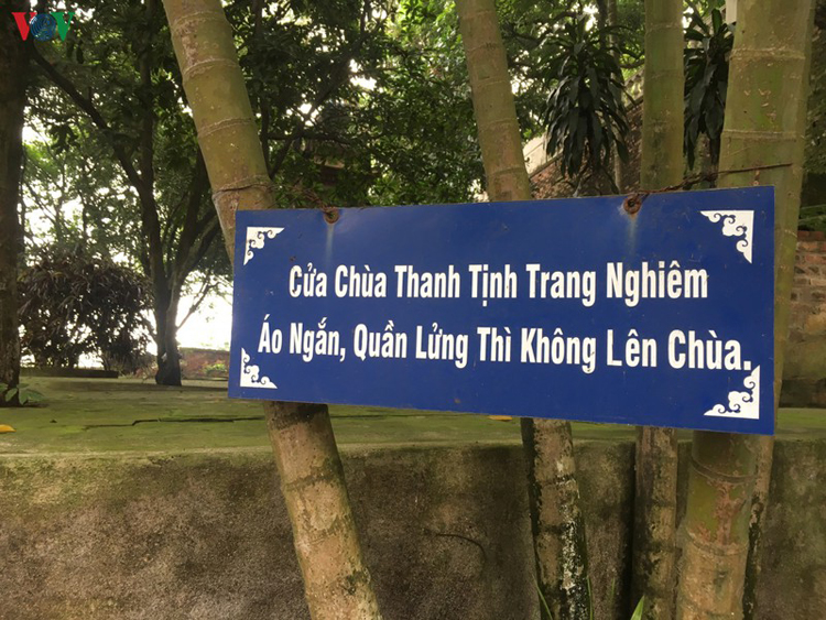 Tấm biển nhắc nhở du khách chỉnh đốn trang phục được đặt ngay bên trái lối đi lên khu Tam Bảo ở chùa Tiêu.