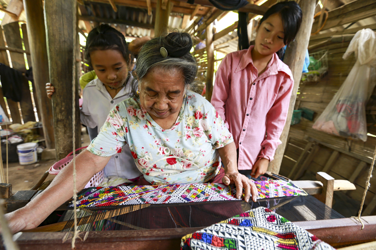 Bà Lò Thị Lún truyền dạy nghề dệt thổ cẩm Lào cho thế hệ trẻ.