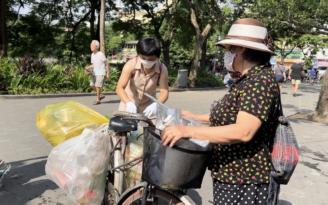 Bà Phương và TNV đưa những túi rác đã được phân loại lên chiếc xe đạp để mang đến nơi nhận tái chế.