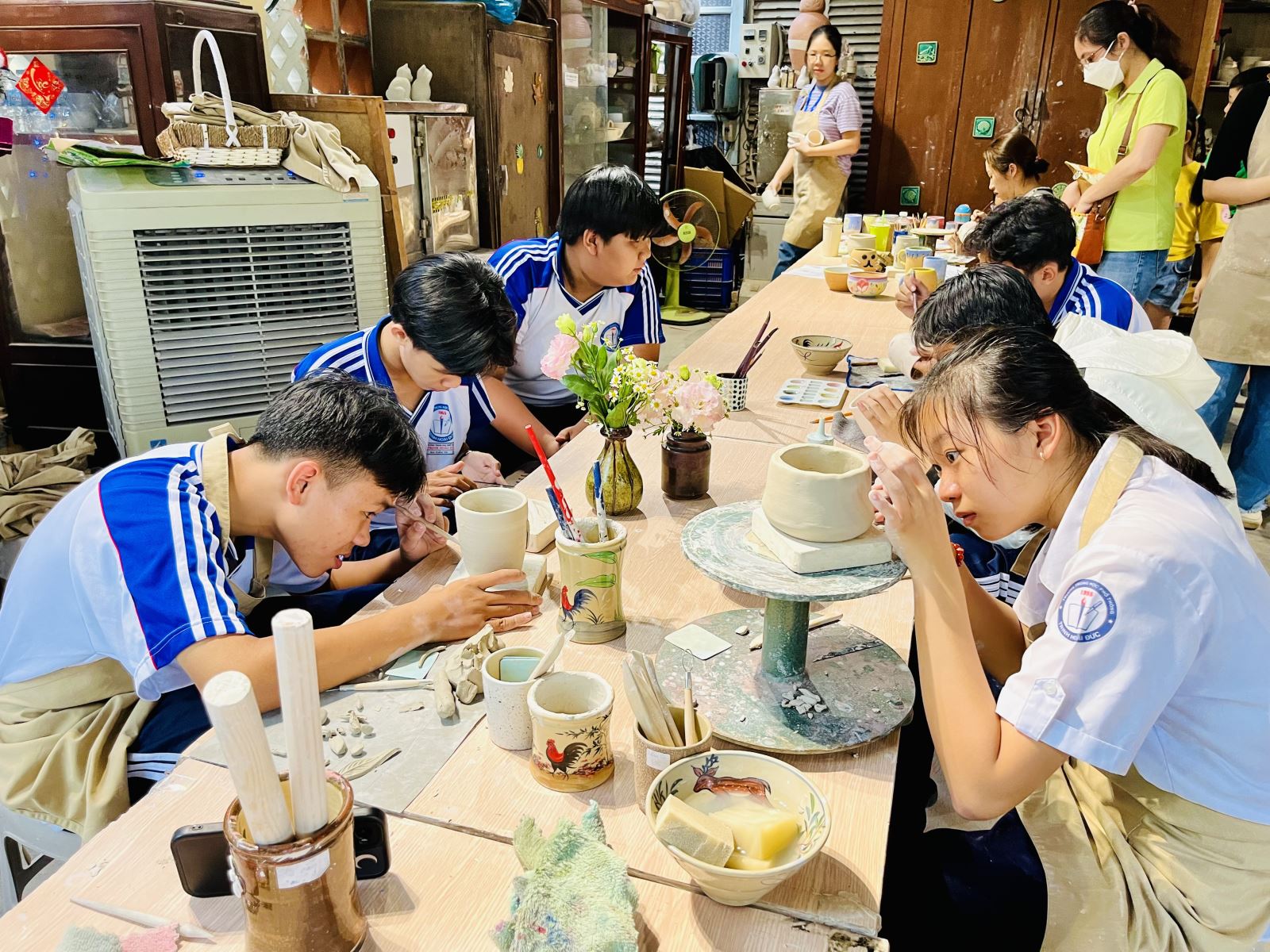 Nhóm học sinh đến từ Trường THPT Trịnh Hoài Đức say sưa làm gốm thủ công.