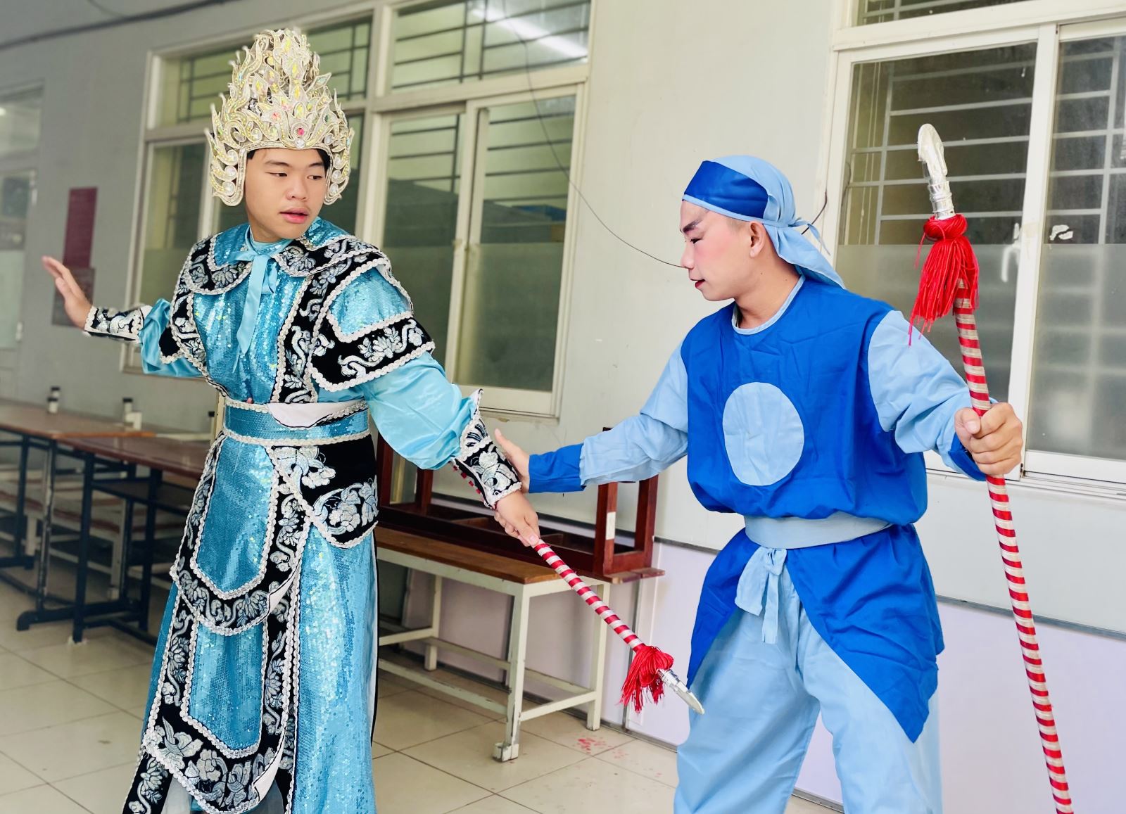 Bạn trẻ Hồ Tấn Phong (bên trái) thích thú khi được trải nghiệm tìm hiểu về nghệ thuật cải lương tuồng cổ ngay tại sân trường.