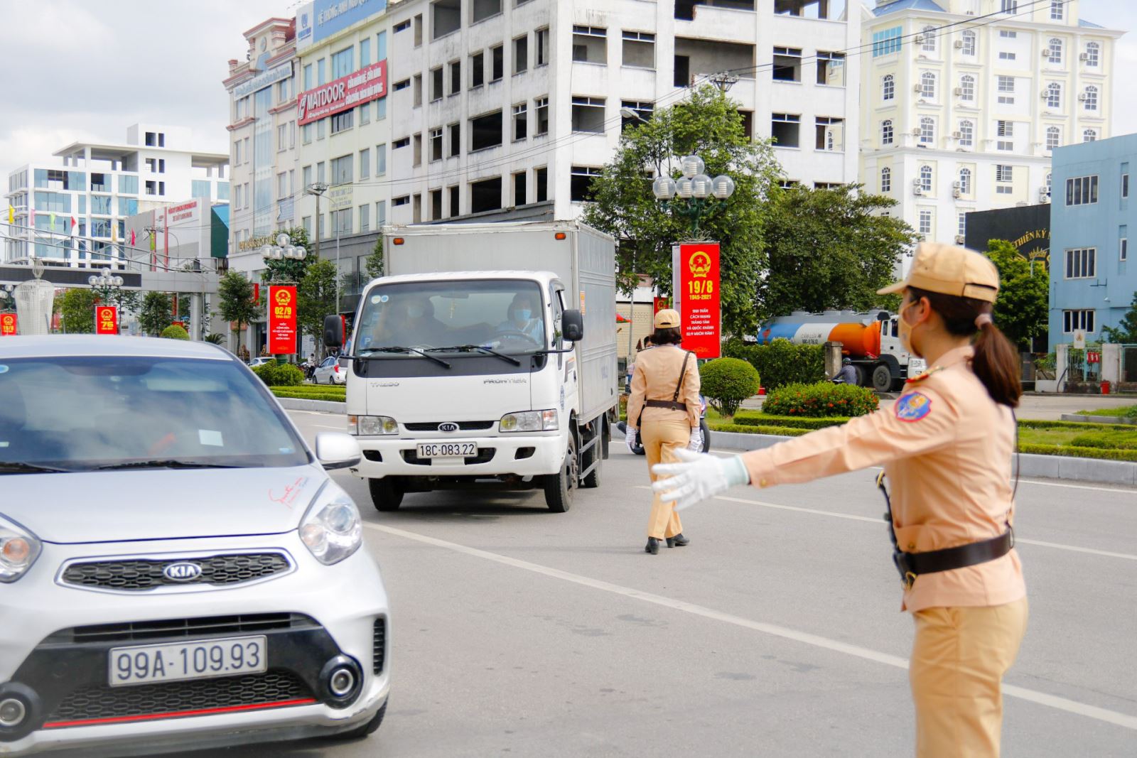 Các nữ cảnh sát đang ra tín hiệu dừng phương tiện, kiểm tra việc chấp hành quy định phòng, chống dịch Covid-19 trên xe. 