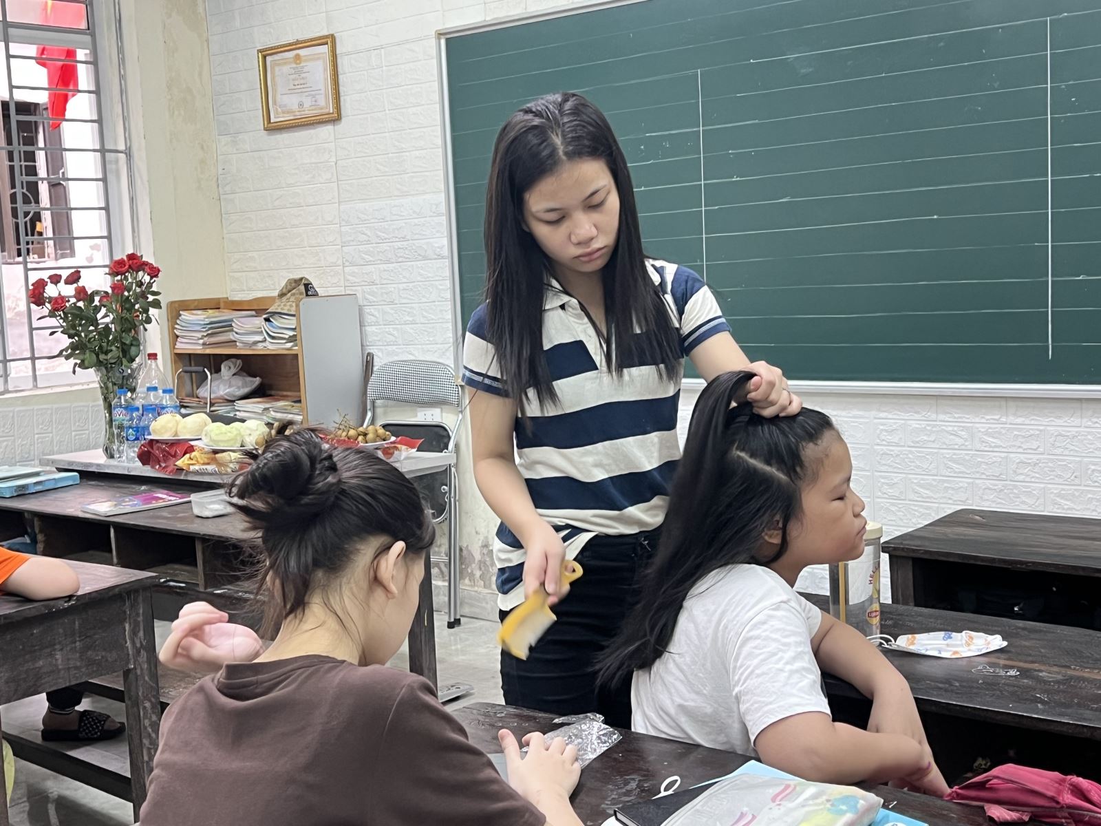 Phạm Thị Hoài, 20 tuổi đang học kiến thức lớp 5, làm lớp trưởng, giúp cô giáo quản lý lớp và chăm sóc cho các bạn nhỏ hơn.