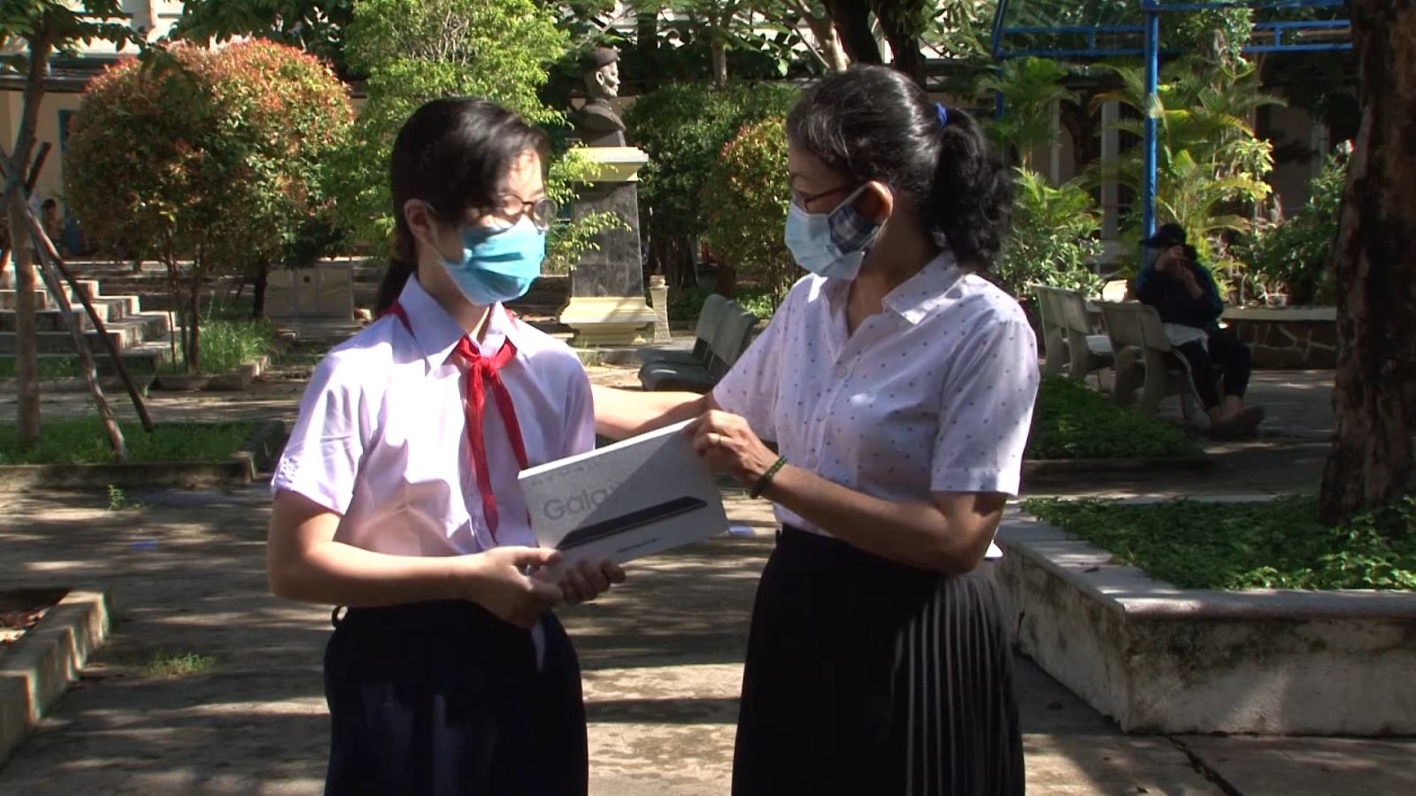 Cô Nguyễn Thị An, hiệu trưởng Trường THCS Huỳnh Thúc Kháng trao tận tay học sinh có hoàn cảnh khó khăn chiếc máy tính bảng.