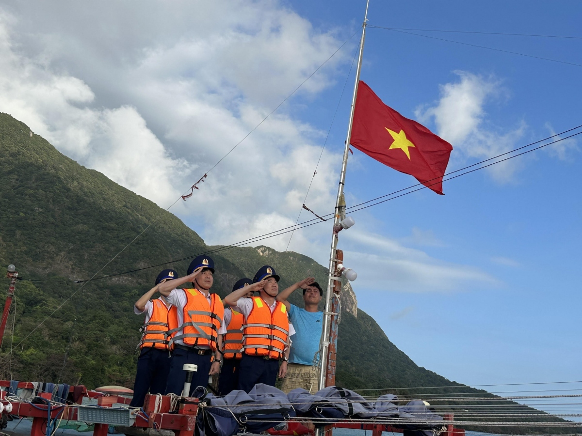 Đoàn công tác thay cờ Tổ quốc cho tàu ngư dân Côn Đảo, cùng ngư dân chào cờ.