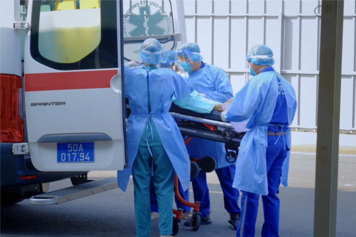 Diễn tập Covid-19 Tết Nguyên đán 2023: Ê kíp cấp cứu (mặc áo quần phòng hộ và đeo khẩu trang N95) di chuyển người bệnh xuống xe và bàn giao cho nhân viên y tế tại khu Hồi sức tích cực của Bệnh viện dã chiến số 13 (Ảnh: Sở Y tế TP.HCM).