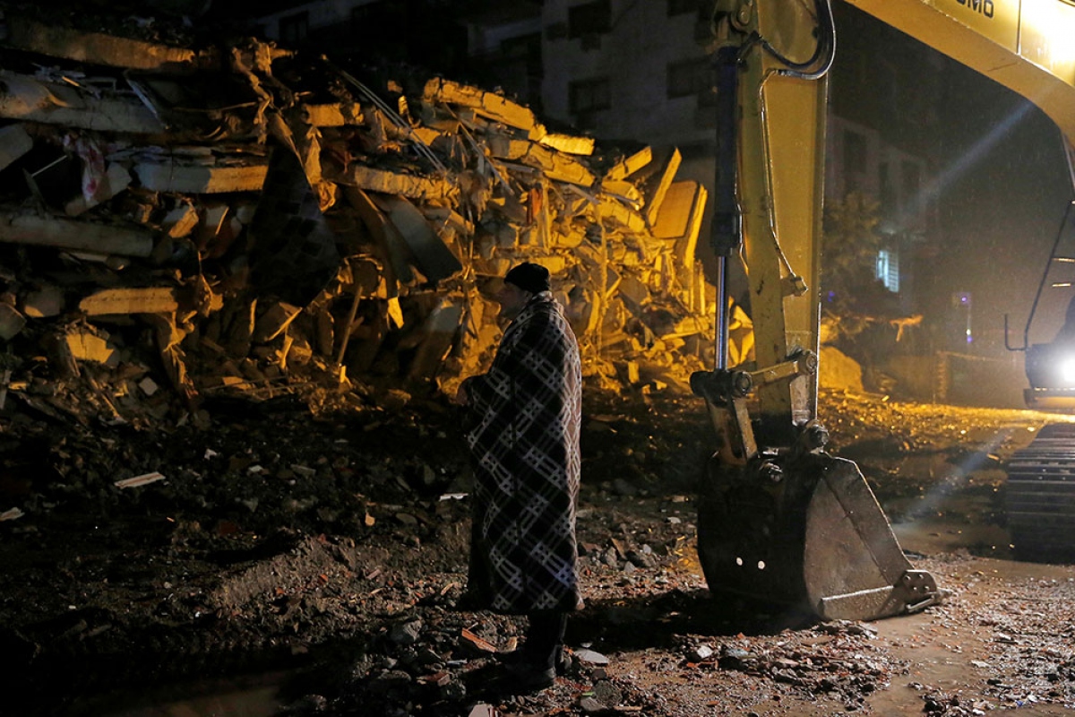 Một người đàn ông đứng trước đống đổ nát của một tòa nhà ở Osmaniye, Thổ Nhĩ Kỳ. Ảnh: Reuters