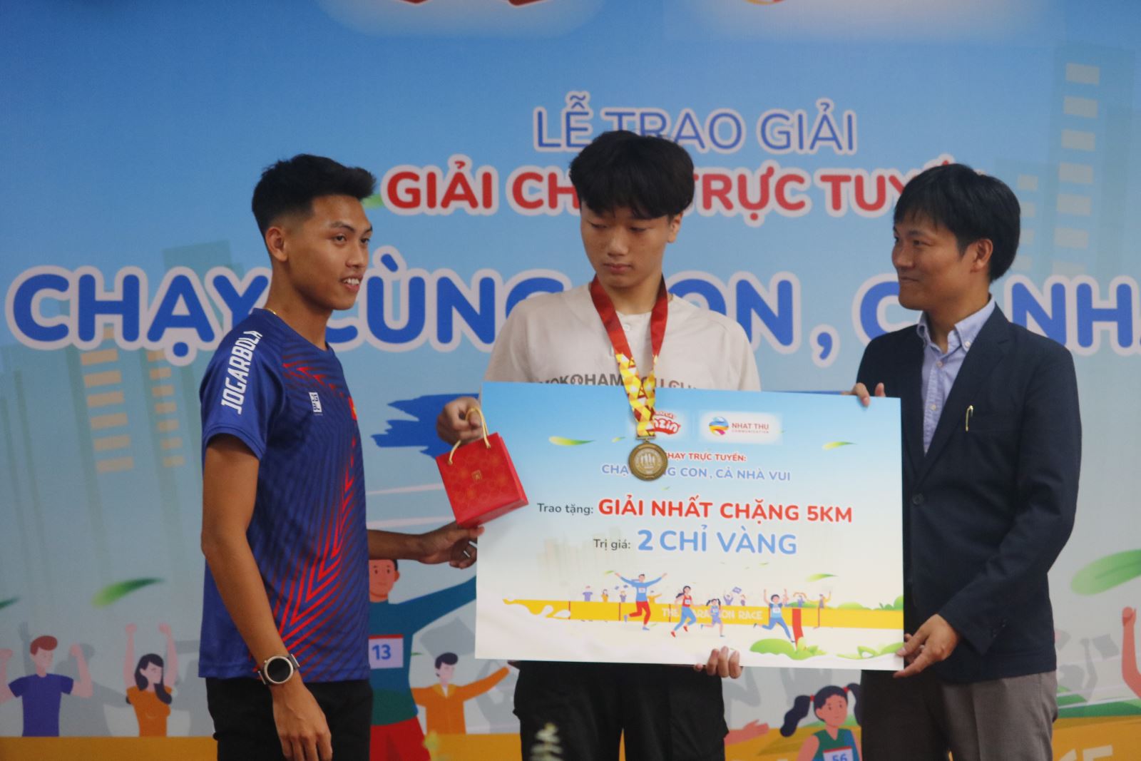VĐV Trần Văn Đảng trao giải thưởng cho bé Đức Tin.