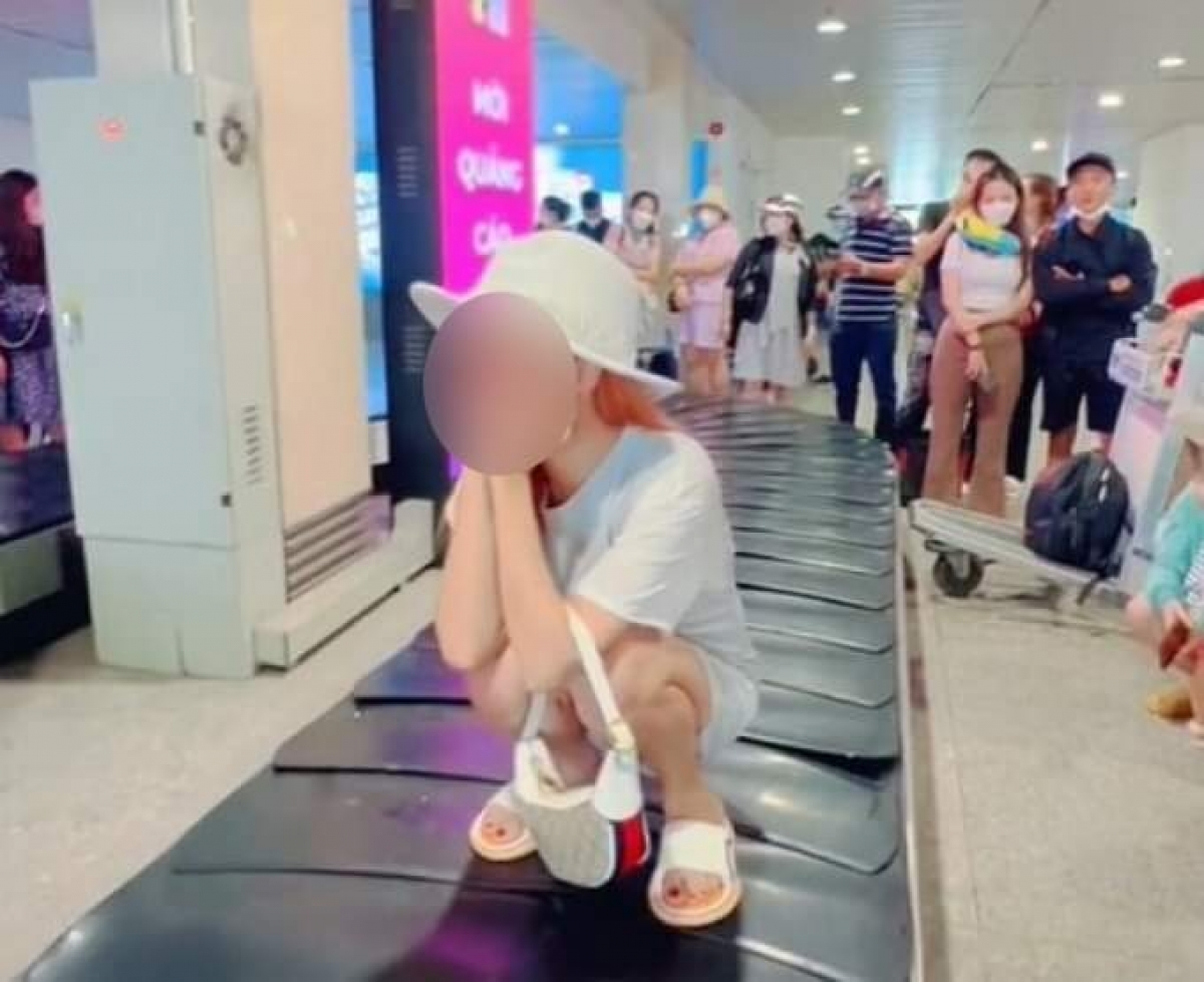Cô gái tạo dáng trên băng chuyền hành lý sân bay để quay TikTok.