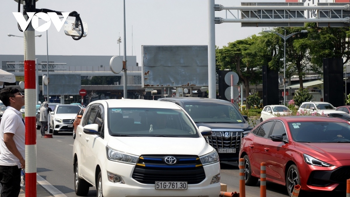 Dù tình trạng ùn tắc đã giảm nhưng dòng xe vẫn phải xếp hàng dài tại Trạm thu phí sân bay Tân Sơn Nhất do hiện mới chỉ thí điểm một làn thu phí không dừng.