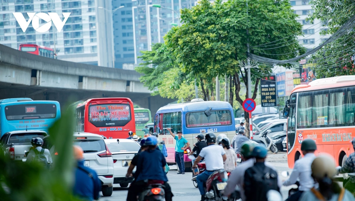 Hàng loạt ô tô đứng giữa đường để đón trả khách trên đường Phạm Hùng.